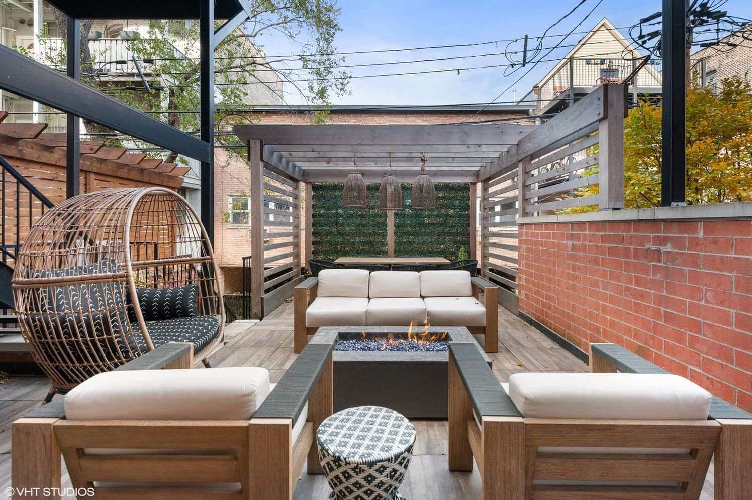 Cozy outdoor seating area with wooden furniture and string lights.