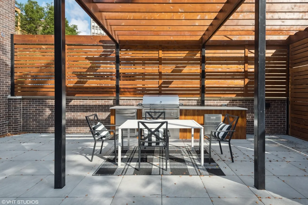 Outdoor patio with table and barbecue grill.